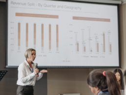 Woman presenting at a City Hall Meeting with audio visual equipment