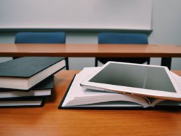 tablet and books stacked on a classroom desk